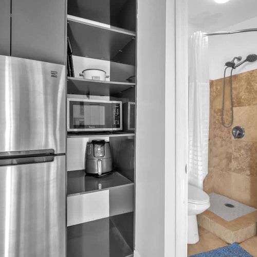 The unit includes a kitchenette with a refrigerator, microwave, coffee maker, air fryer, toaster, and sink (please note: no stove).