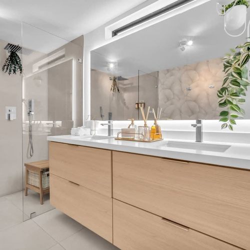 Spacious bathroom with dual shower heads, a roomy sink, and mirror—perfect for sharing with family or friends.