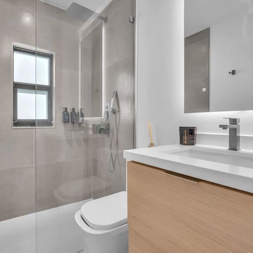 Spacious bathroom featuring a single shower, sink, and mirror.