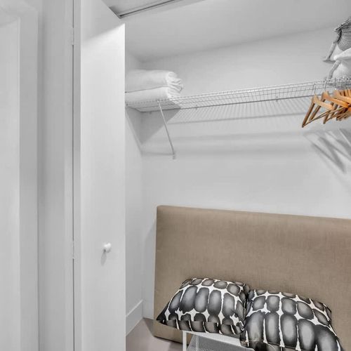 Spacious closet with a hanging rack and plenty of hangers for your convenience.