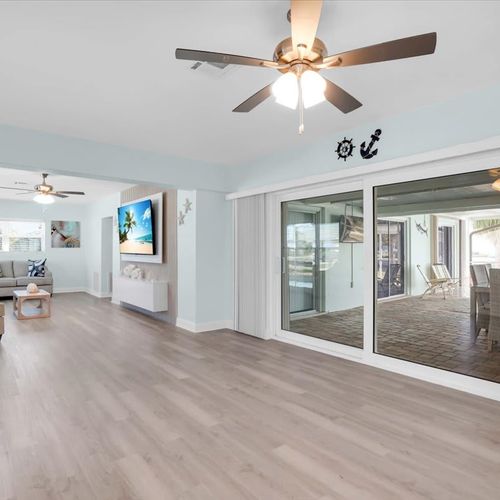 Open, bright living room with plenty of cozy seating and a widescreen TV—great for movie nights or casual hangouts.