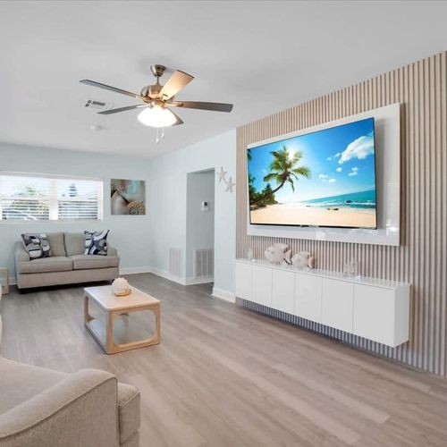 Open, bright living room with plenty of cozy seating and a widescreen TV—great for movie nights or casual hangouts.