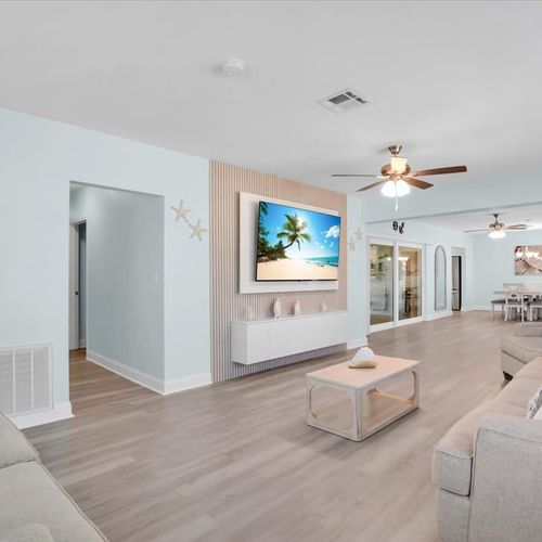 Open, bright living room with plenty of cozy seating and a widescreen TV—great for movie nights or casual hangouts.