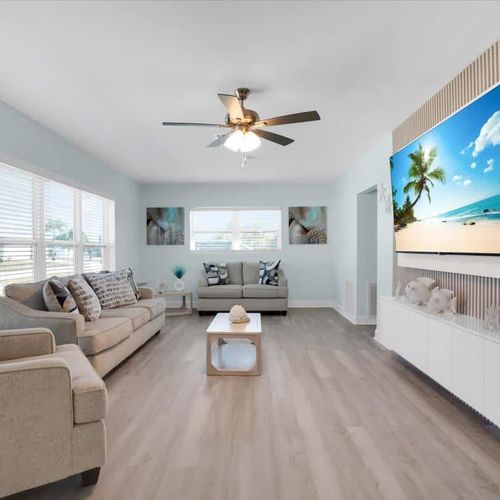 Open, bright living room with plenty of cozy seating and a widescreen TV—great for movie nights or casual hangouts.