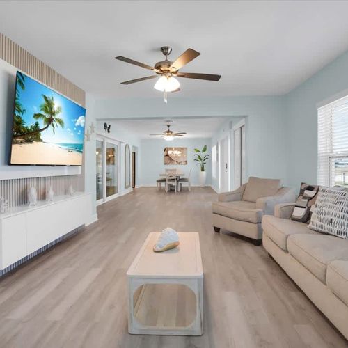 Open, bright living room with plenty of cozy seating and a widescreen TV—great for movie nights or casual hangouts.