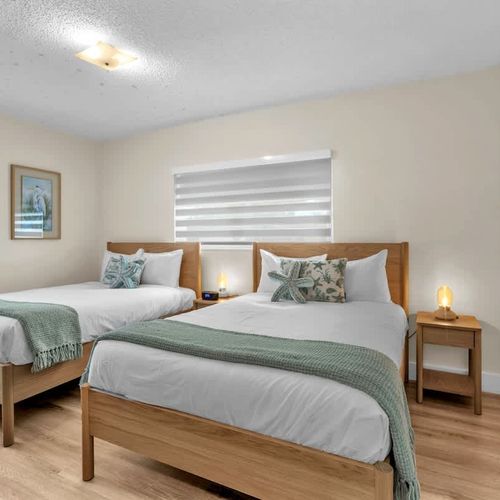 Well-appointed bedroom with two full beds, designed for restful nights and easy group accommodations.