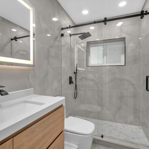 This stylish bathroom offers a walk-in shower, elegant tile work, and modern fixtures for a relaxing, refreshed feel.