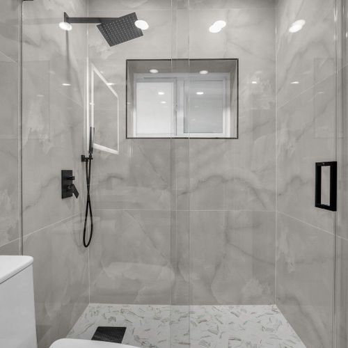 This stylish bathroom offers a walk-in shower, elegant tile work, and modern fixtures for a relaxing, refreshed feel.