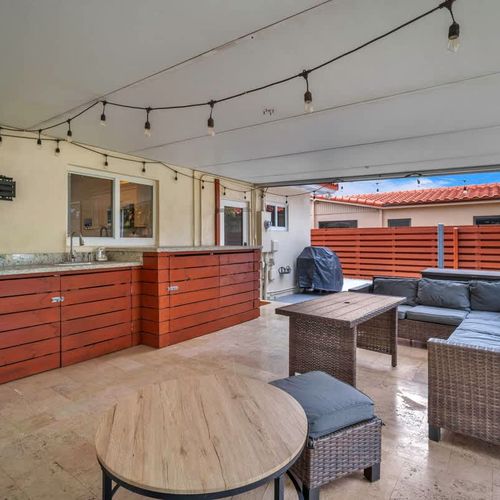 Enjoy a private backyard retreat featuring a grassy yard, peaceful greenery, a swing set, and a comfortable patio for relaxing outdoors.