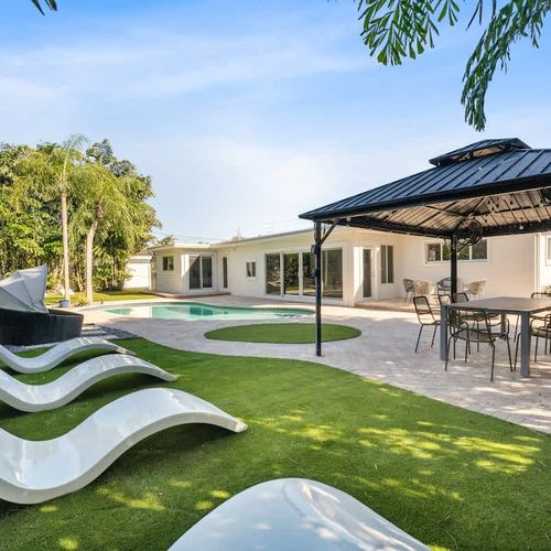 Large outdoor area with a pool, sun loungers, and covered seating for relaxing or dining outside.