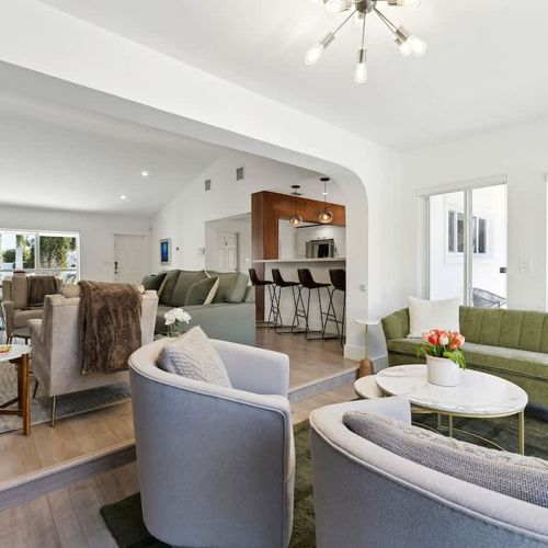 Stylish secondary living area featuring comfortable seating and large glass doors that open to relaxing pool and backyard views.