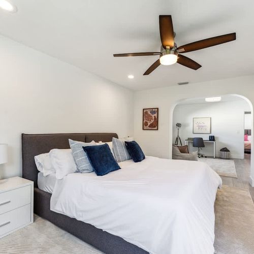 Comfortable king-size bed with crisp linens and layered pillows, perfect for unwinding after a long day.