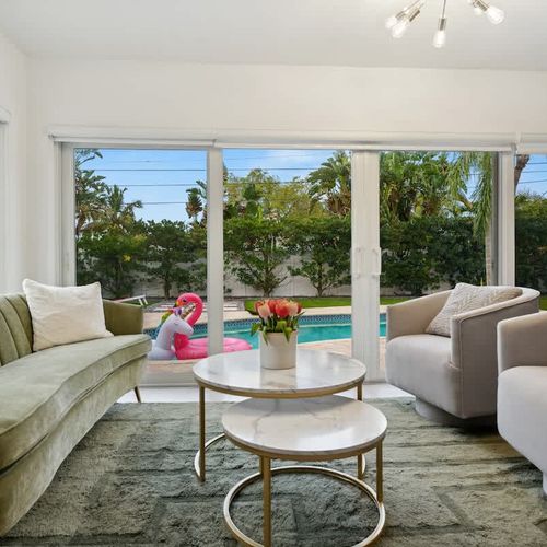 Stylish secondary living area featuring comfortable seating and large glass doors that open to relaxing pool and backyard views.