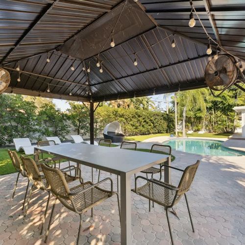 Shaded patio ideal for coffee in the morning, relaxing afternoons, and evening meals illuminated by soft string lights.