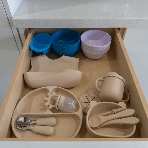 Drawers and cupboards are neatly organized and supplied with essential cookware, dishware, and dining items.
