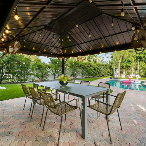Shaded patio ideal for coffee in the morning, relaxing afternoons, and evening meals illuminated by soft string lights.