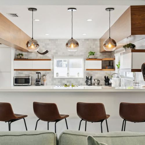 Modern open kitchen with a spacious breakfast bar, comfortable counter seating, and stylish pendant lighting—perfect for casual meals and conversation.