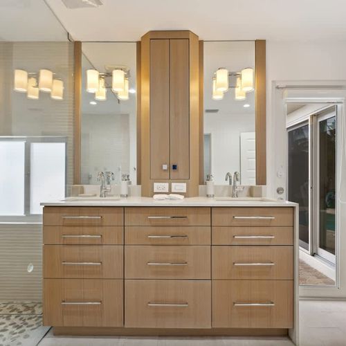 Elegant, spa-inspired primary bathroom with warm wood cabinetry, sleek finishes, and a bright, modern aesthetic.