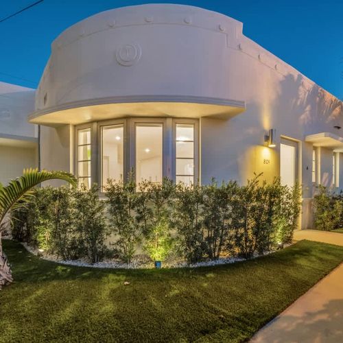 Featuring elegant curved architecture, floor-to-ceiling windows, and beautifully landscaped gardens. Relax in the warm glow of exterior lighting at dusk.