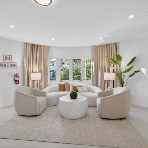 Bright and airy living room with large windows, offering a relaxing ambiance and serene pool views.