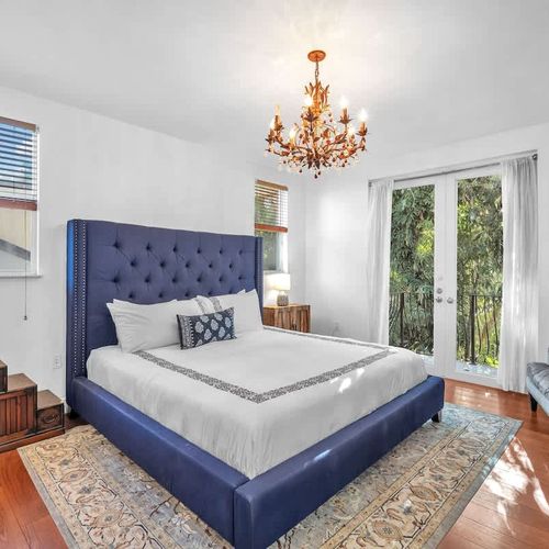 Bright bedroom with a king bed, modern décor, and backyard views. Perfect for relaxing in Coconut Grove, Miami.