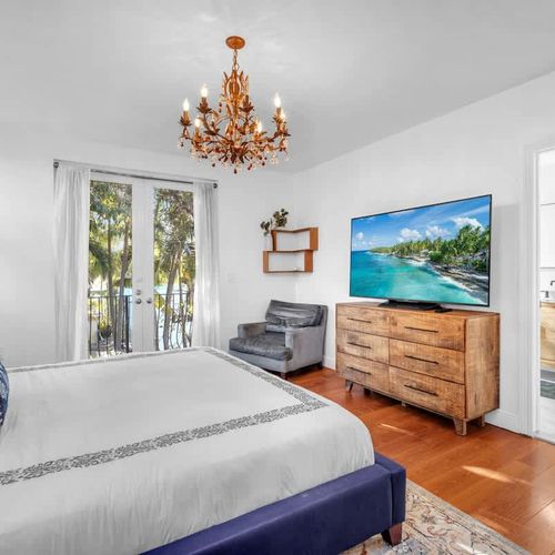 Bedroom 1 with a TV and a full bathroom, offering serene outdoor views.