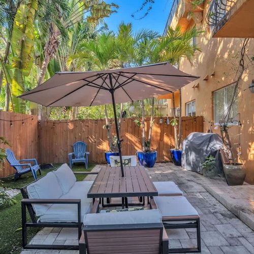 A private, fully fenced backyard with seating and lush trees for peaceful outdoor moments.
