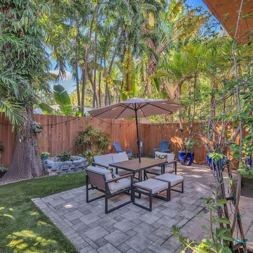 Relax in our backyard oasis, surrounded by lush tropical trees and plants—perfect for lounging or enjoying casual meals.