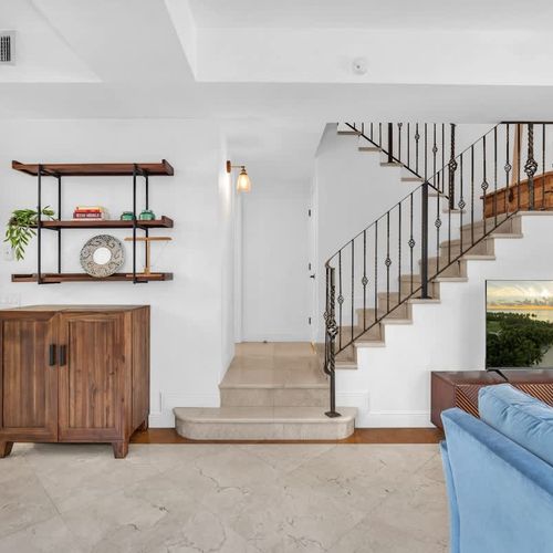 Open living space with easy access to the upper floor via a chic staircase, near the kitchen and lounge.