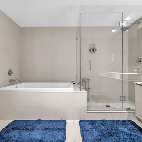 Well-appointed bathroom with a soaking tub, walk-in glass shower, and dual sinks designed for comfort and convenience.