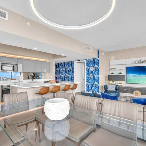 Elegant dining area featuring a modern glass table with seating for up to 8 guests, offering a comfortable setting for shared meals.