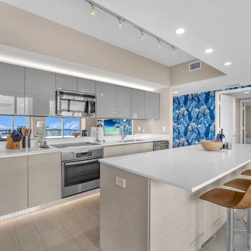 Fully equipped gourmet kitchen with stainless steel appliances, sleek cabinetry, and a spacious island perfect for cooking and entertaining.