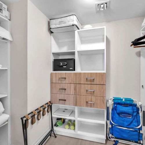 Large closet equipped with built-in storage, hanging space, drawers, and a safe to keep your belongings neatly organized.