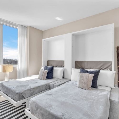 This second bedroom includes two full-size beds and its own TV, creating a cozy and convenient space for children or companions.