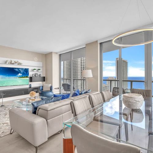 Elegant dining area featuring a modern glass table with seating for up to 8 guests, offering a comfortable setting for shared meals.