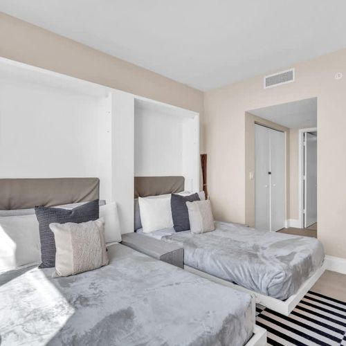 This second bedroom includes two full-size beds and its own TV, creating a cozy and convenient space for children or companions.