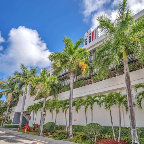 Outside view of the resort with tropical palm trees and a sunny South Florida vibe.
