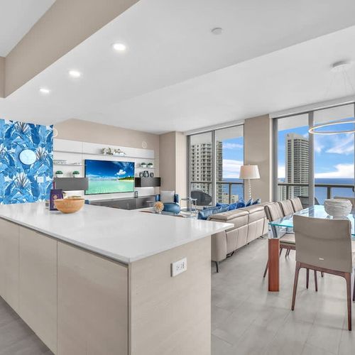 Elegant dining area featuring a modern glass table with seating for up to 8 guests, offering a comfortable setting for shared meals.