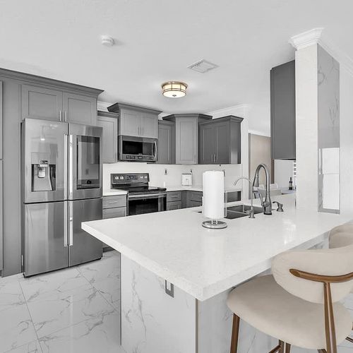 Fully equipped kitchen featuring sleek cabinetry, modern finishes, and comfortable counter seating.