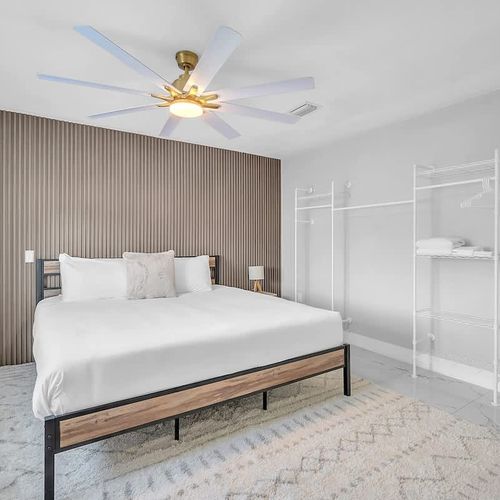 Cozy bedroom with a statement accent wall, soft lighting, and convenient open shelving for storage.
