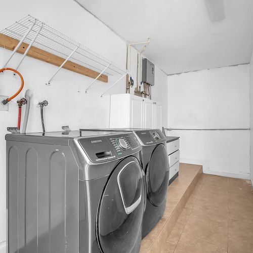 Convenient in-home laundry room with modern washer and dryer, plus shelving for easy storage during your stay.
