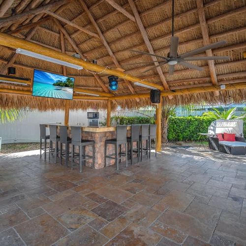 Spacious shaded outdoor lounge with bar seating, perfect for relaxing or entertaining.