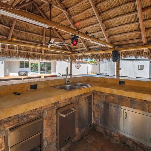 Fully equipped tiki bar—perfect for mixing drinks and hosting by the pool.