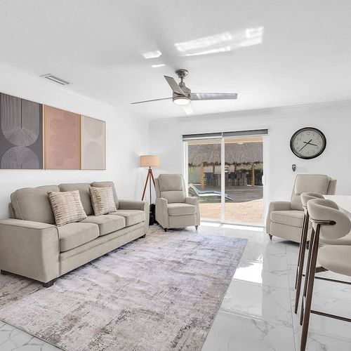 Open-concept living area featuring a spacious sofa, bar seating, and plenty of natural light throughout.