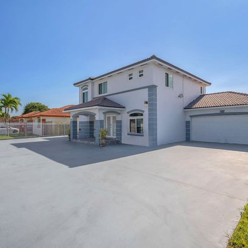 Spacious corner perspective showcasing the home’s size and fenced perimeter.