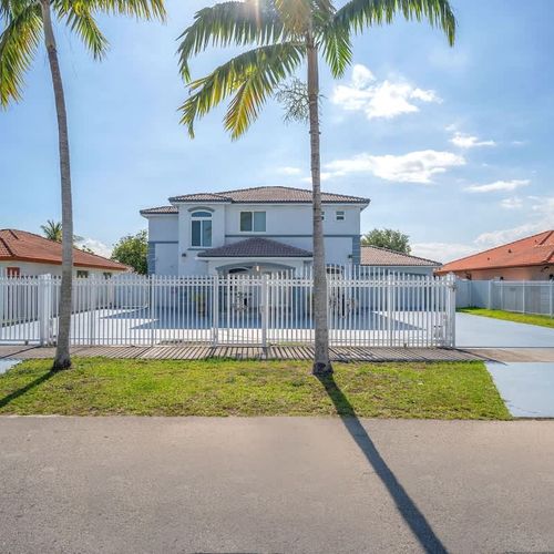 Quiet neighborhood setting with palm-lined streets and beautiful curb appeal.