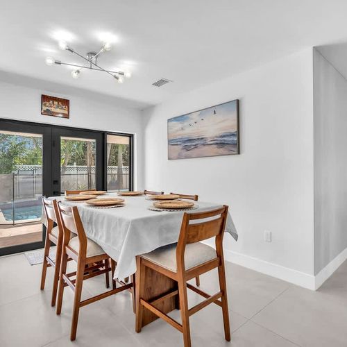 Enjoy breakfast, dinner, or late-night conversations in this welcoming dining space with natural light and relaxing pool views just steps away.