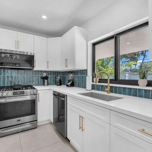 Prepare everything from full home-cooked meals to quick poolside snacks in this bright modern kitchen featuring updated appliances, generous counter space, and a fresh coastal-inspired design.