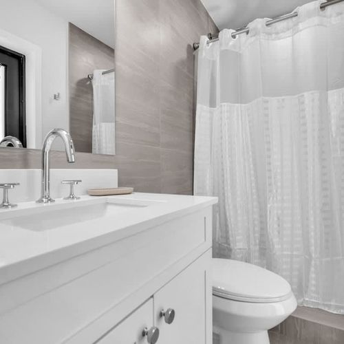 Enjoy a clean, generously sized bathroom with modern finishes and equipped with all the basics, including towels, toiletries essentials, and a convenient hair dryer.