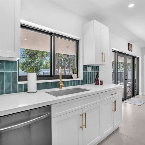 Prepare everything from full home-cooked meals to quick poolside snacks in this bright modern kitchen featuring updated appliances, generous counter space, and a fresh coastal-inspired design.